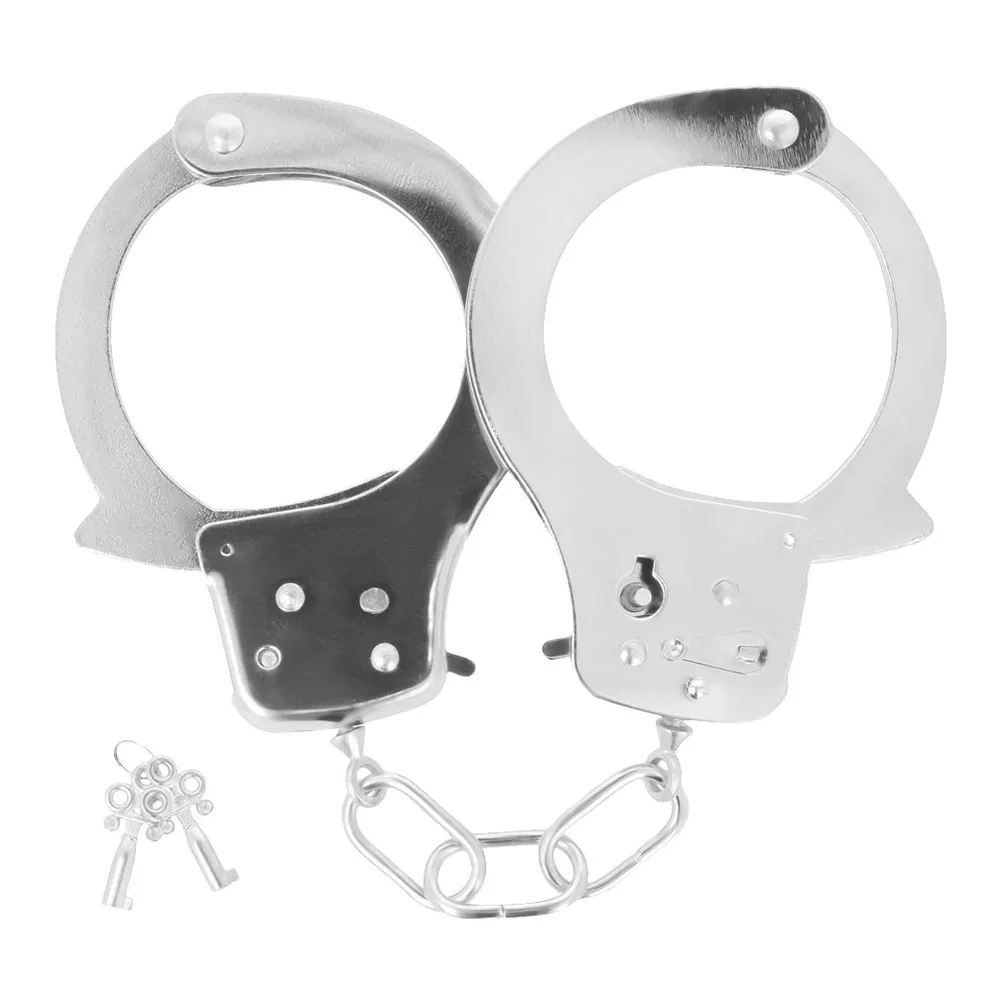 Paire de menottes de chevilles en métal, une noire et une argentée, avec chaîne de liaison, accompagnées de deux clés et d'un loquet de sécurité sur fond blanc