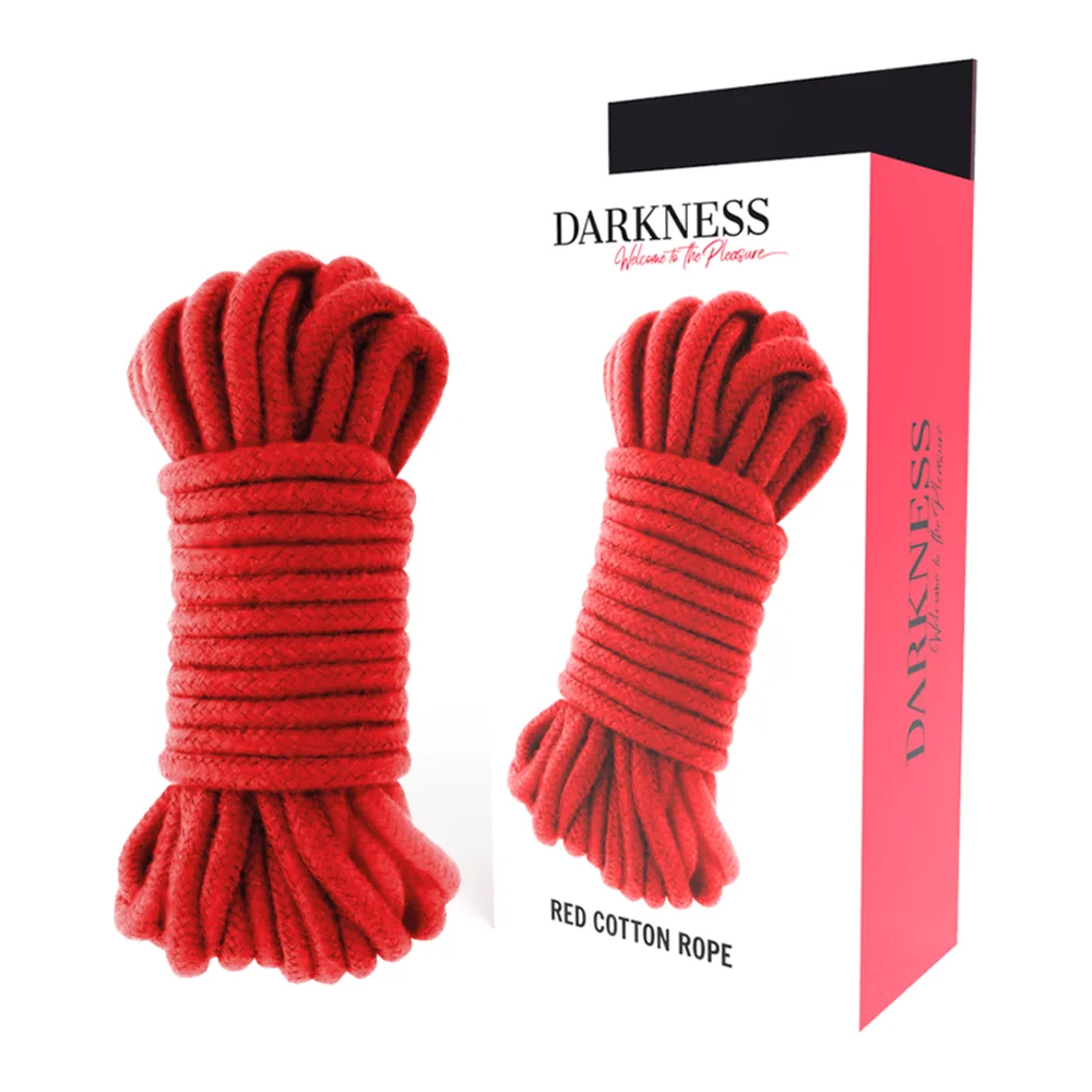 Corde de bondage en coton rouge enroulée, avec emballage rose et noir de la marque Darkness montrant le produit déroulé