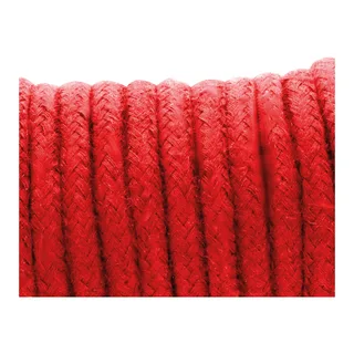 Corde de shibari enroulée posée sur un drap clair