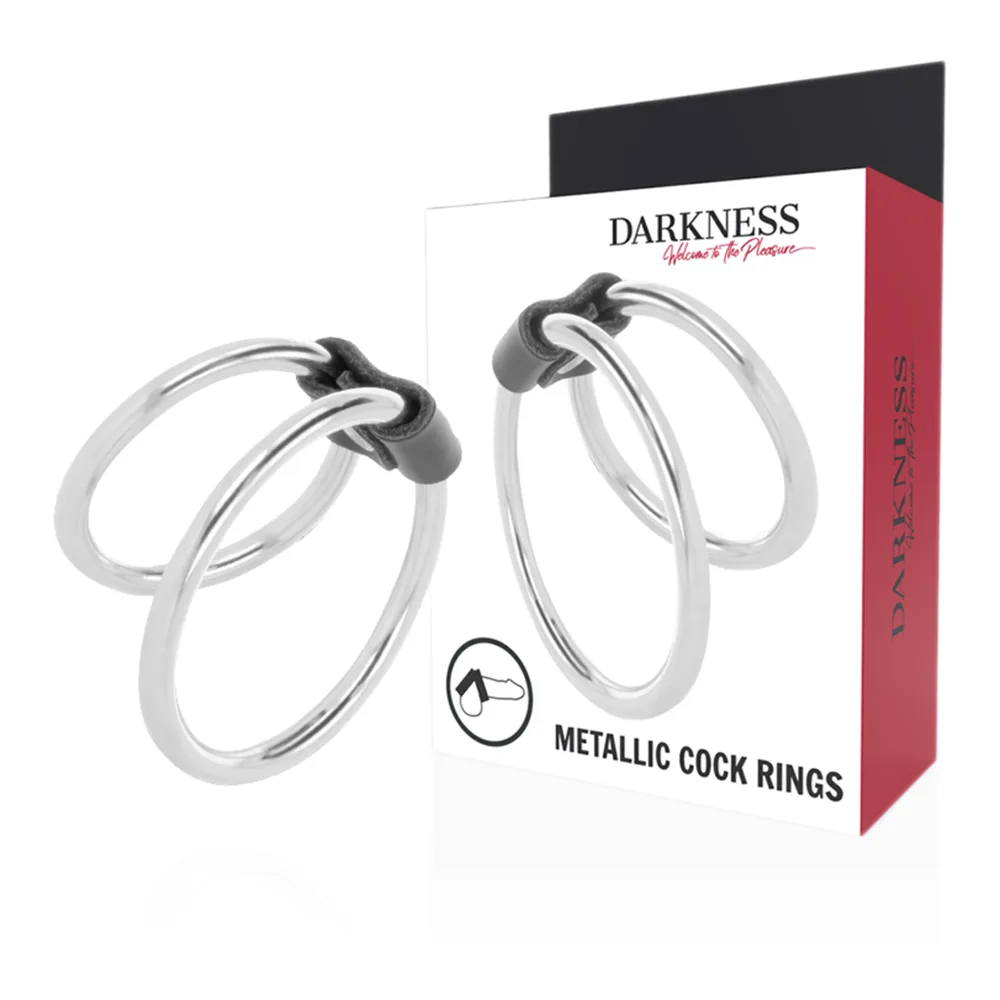 Cockring double en acier poli avec deux anneaux reliés par un lien de cuir noir, présenté sur fond blanc