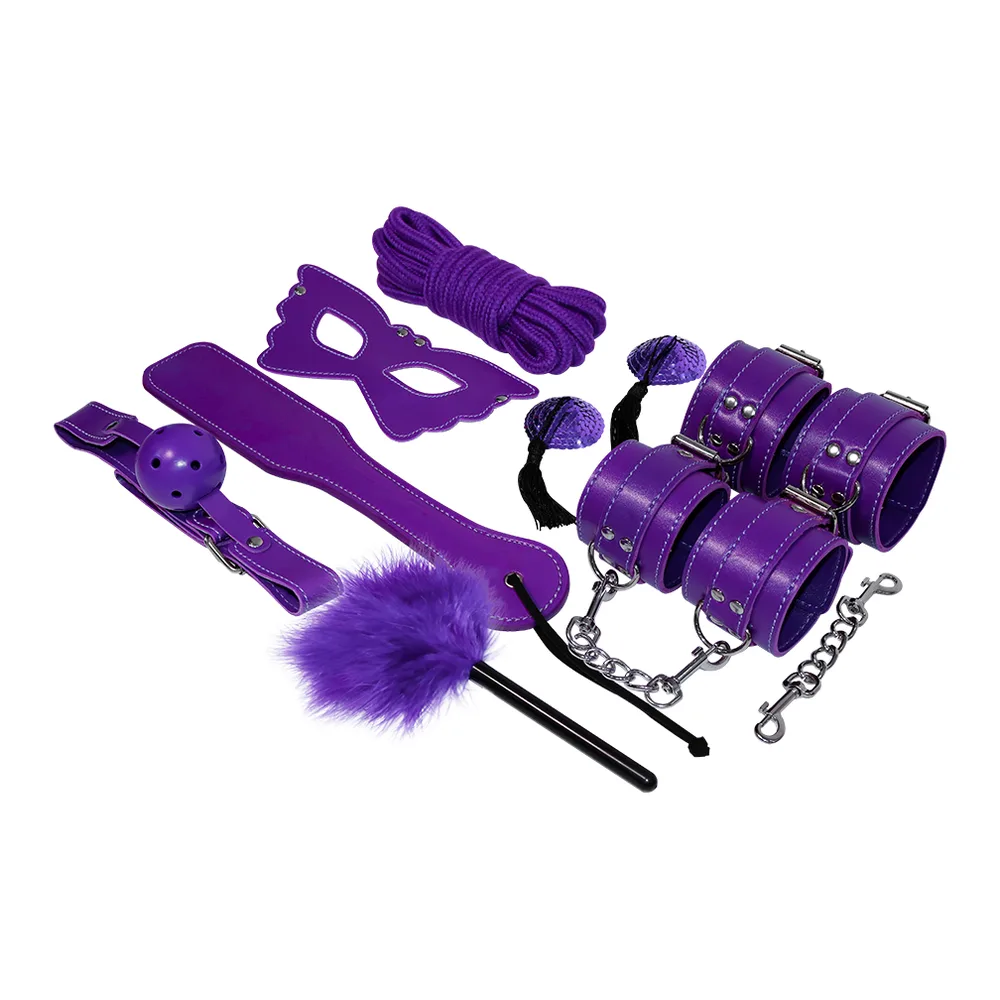 Coffret BDSM en cuir violet comprenant menottes, masque, collier chaîné, corde, fouet à plumes, bracelets et accessoires assortis, présenté avec son emballage
