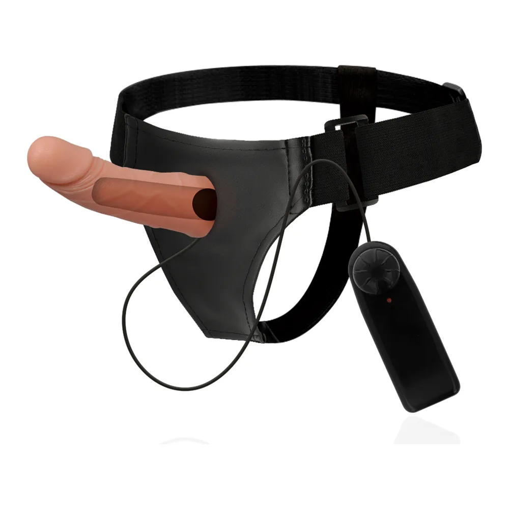 Harnais de cadre noir avec sangle ajustable et boucle, portant un gode creux beige de 15 cm, sur fond blanc