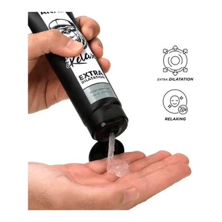 Tube noir de lubrifiant posé dans une main ouverte, gel transparent s'écoulant du tube, avec étiquette blanche indiquant « Extra Dilatation » et icônes de dilatation et relaxation