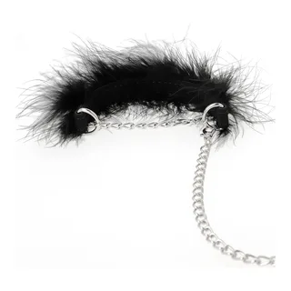 Menottes avec anneaux de métal chromé reliés par une chaîne, bordées de plumes noires duveteuses sur les pourtours intérieurs, fond blanc