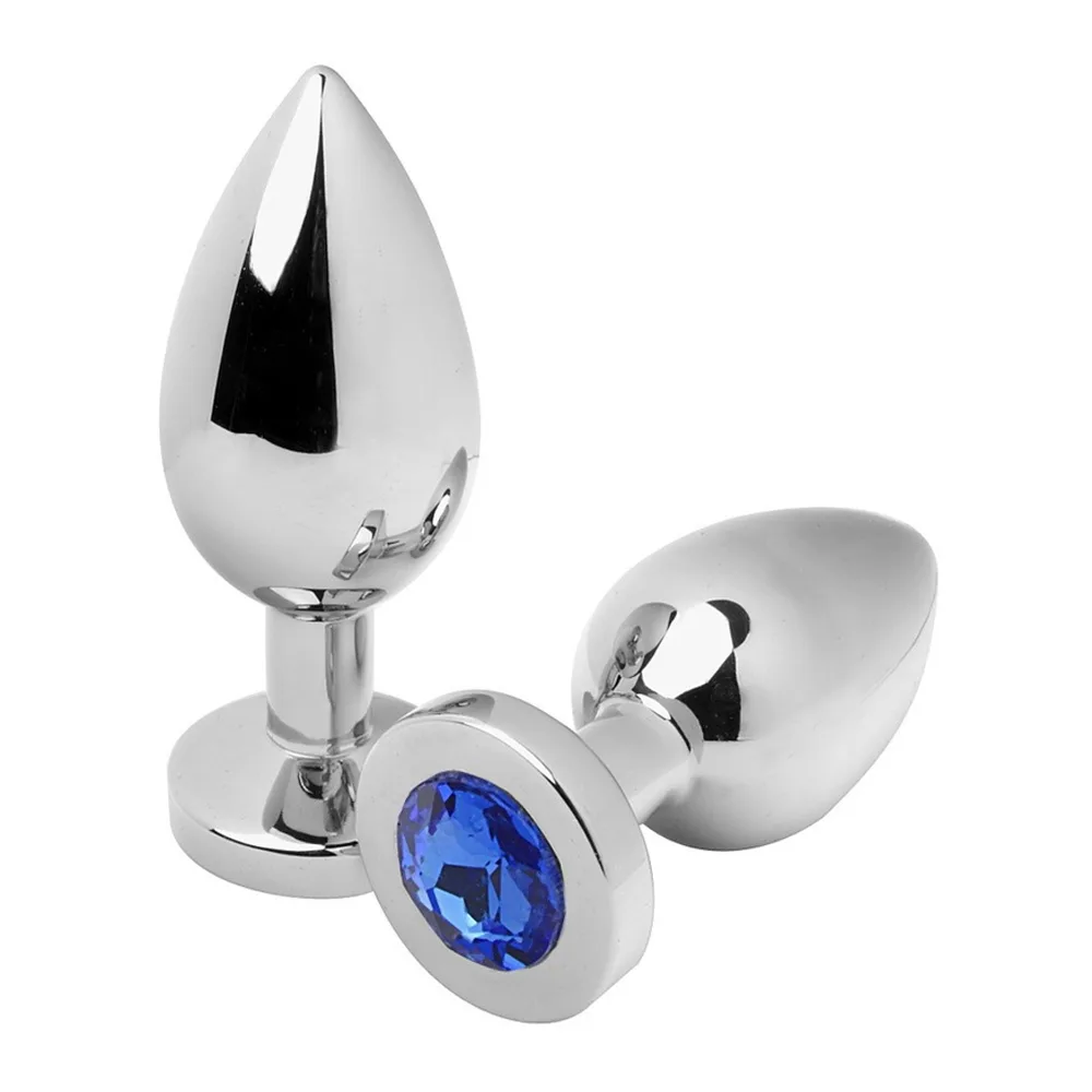 Plug anal en acier poli chromé avec base ovale blanche et pierre bleue serties à l'extrémité, sur fond blanc
