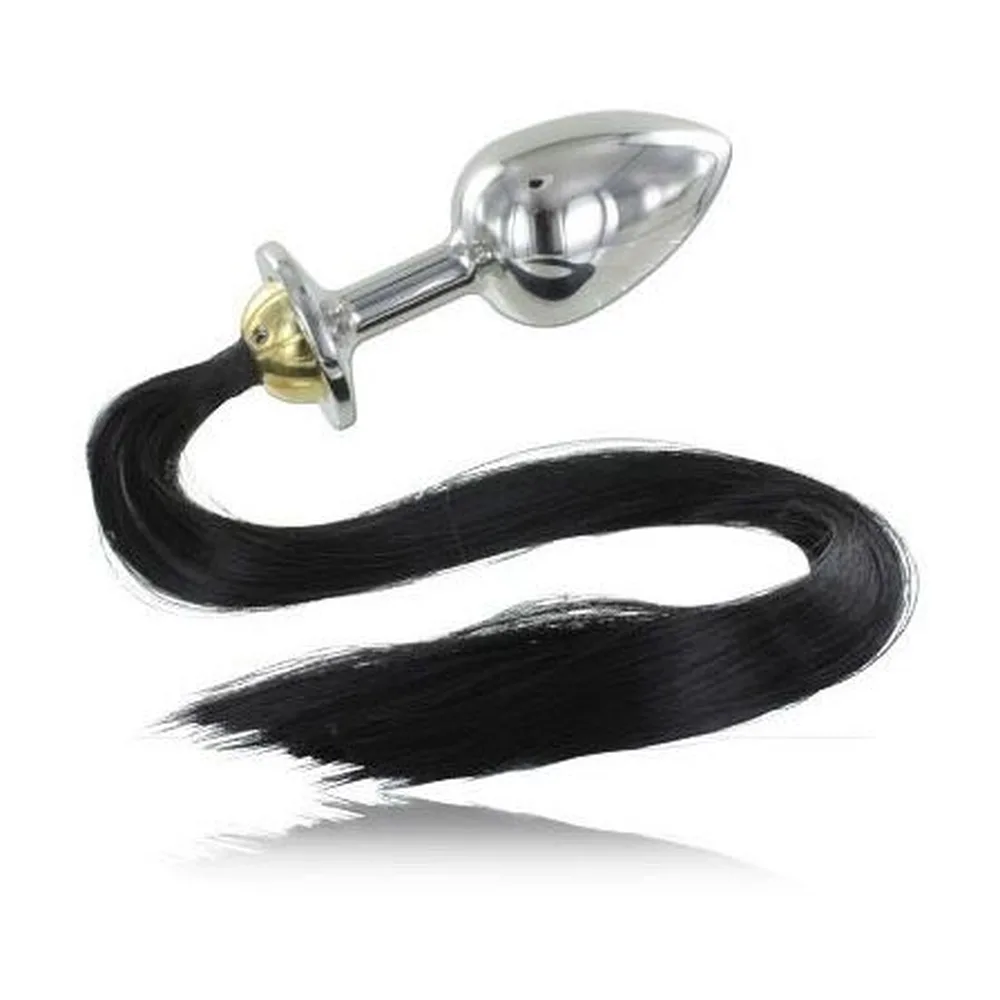 Plug anal en acier poli chromé avec base dorée, prolongé d'une longue queue de cheveux synthétiques noirs ondulants, sur fond blanc