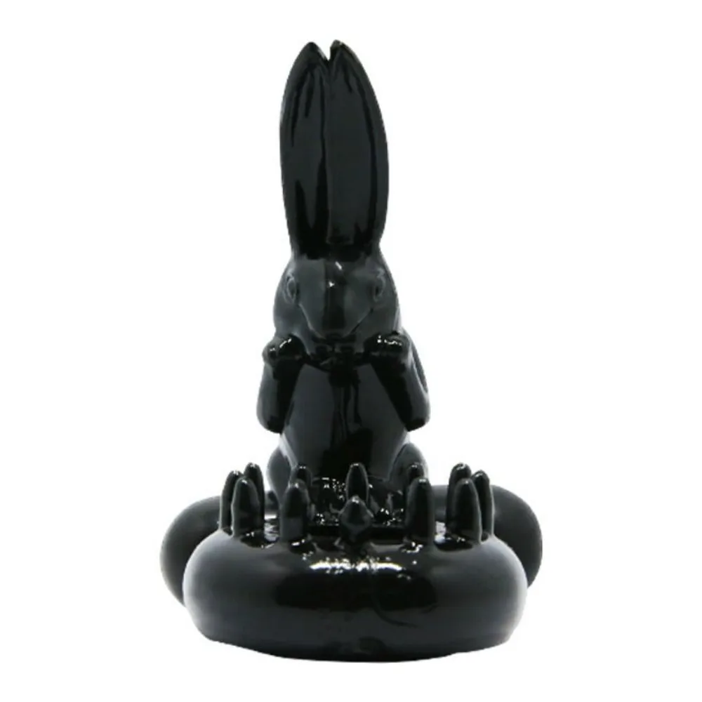 Cockring en silicone noir avec un lapin stylisé en relief et des picots sur la surface, anneau ouvert visible, sur fond blanc