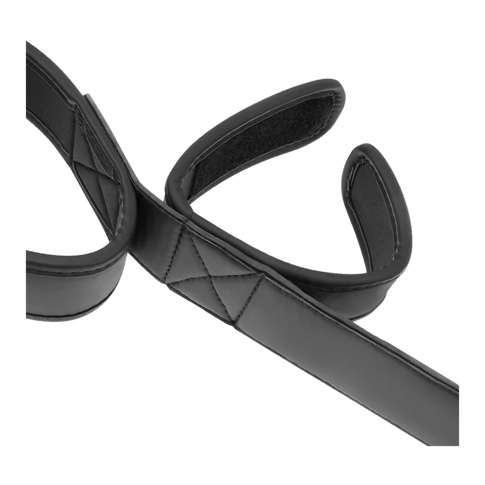 Barre d'écartement noire en cuir synthétique avec bracelets velcro aux extrémités et bande médiane rembourrée de motif piqué, sur fond blanc