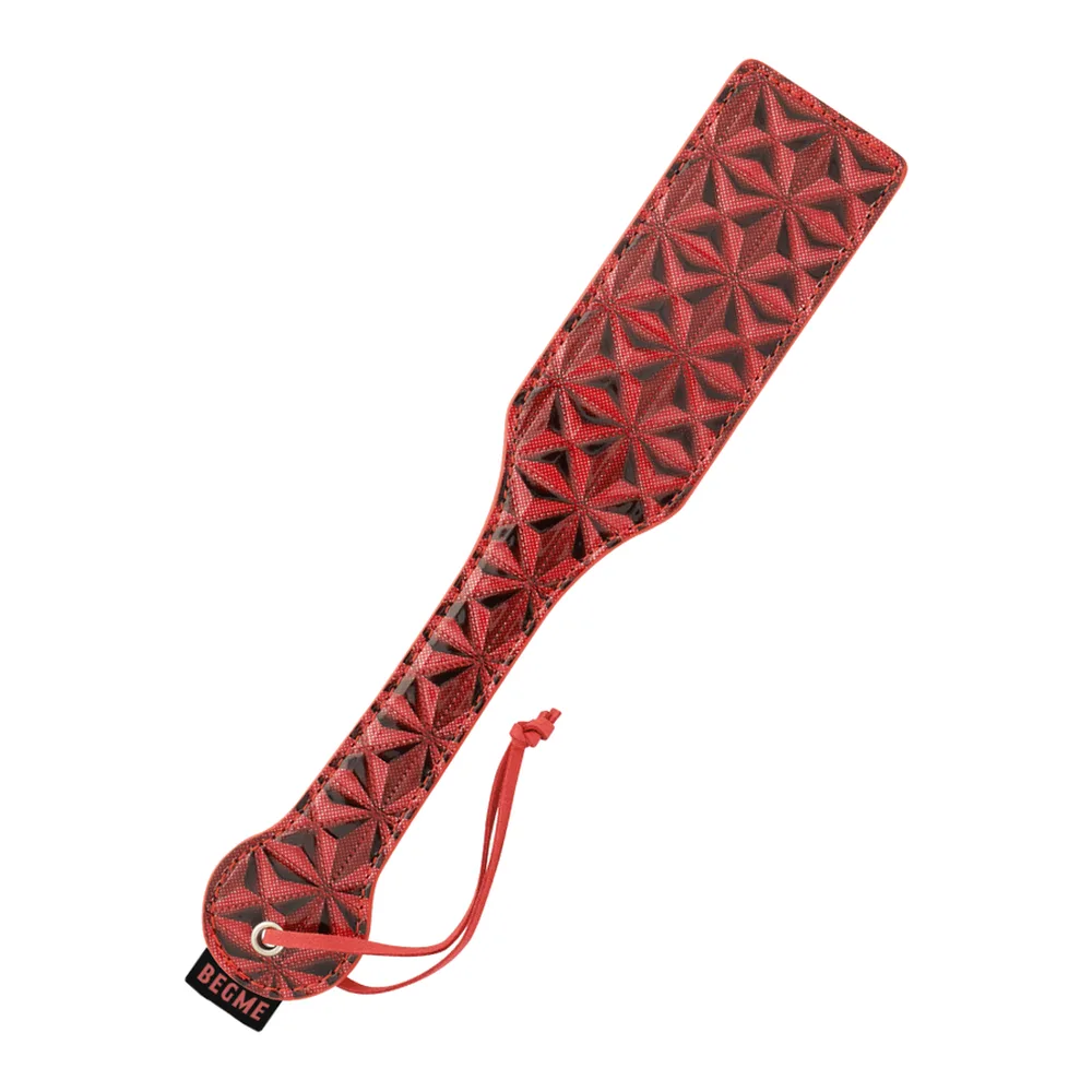 Fessée en cuir vegan rouge avec motif géométrique gaufré en relief, poignée assortie et anneau de rangement métallique, fond blanc