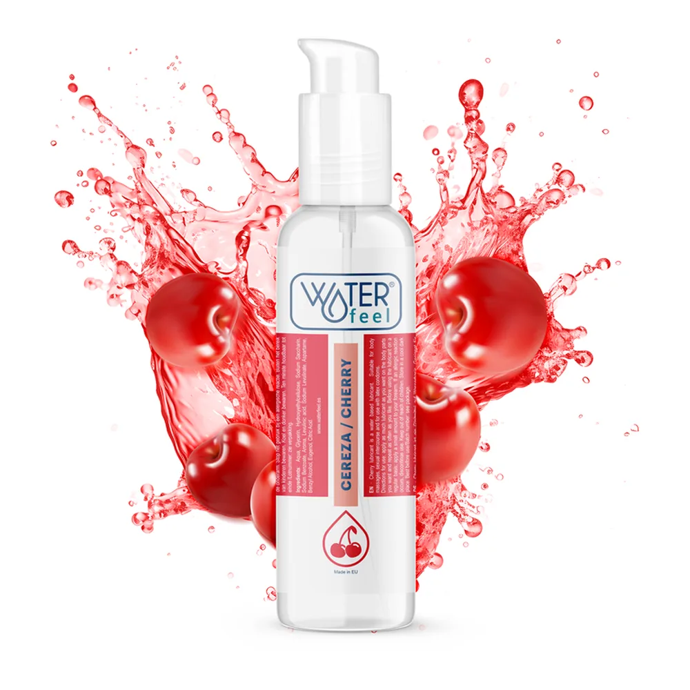 Flacon blanc de lubrifiant aromatisé cerise avec bouchon pompe, entouré d'éclaboussures d'eau rouge et de cerises fraîches sur fond blanc