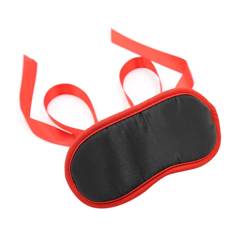 Masque de sommeil noir et rouge avec contour rouge vif et deux lanières nouables en satin rouge vif sur fond blanc