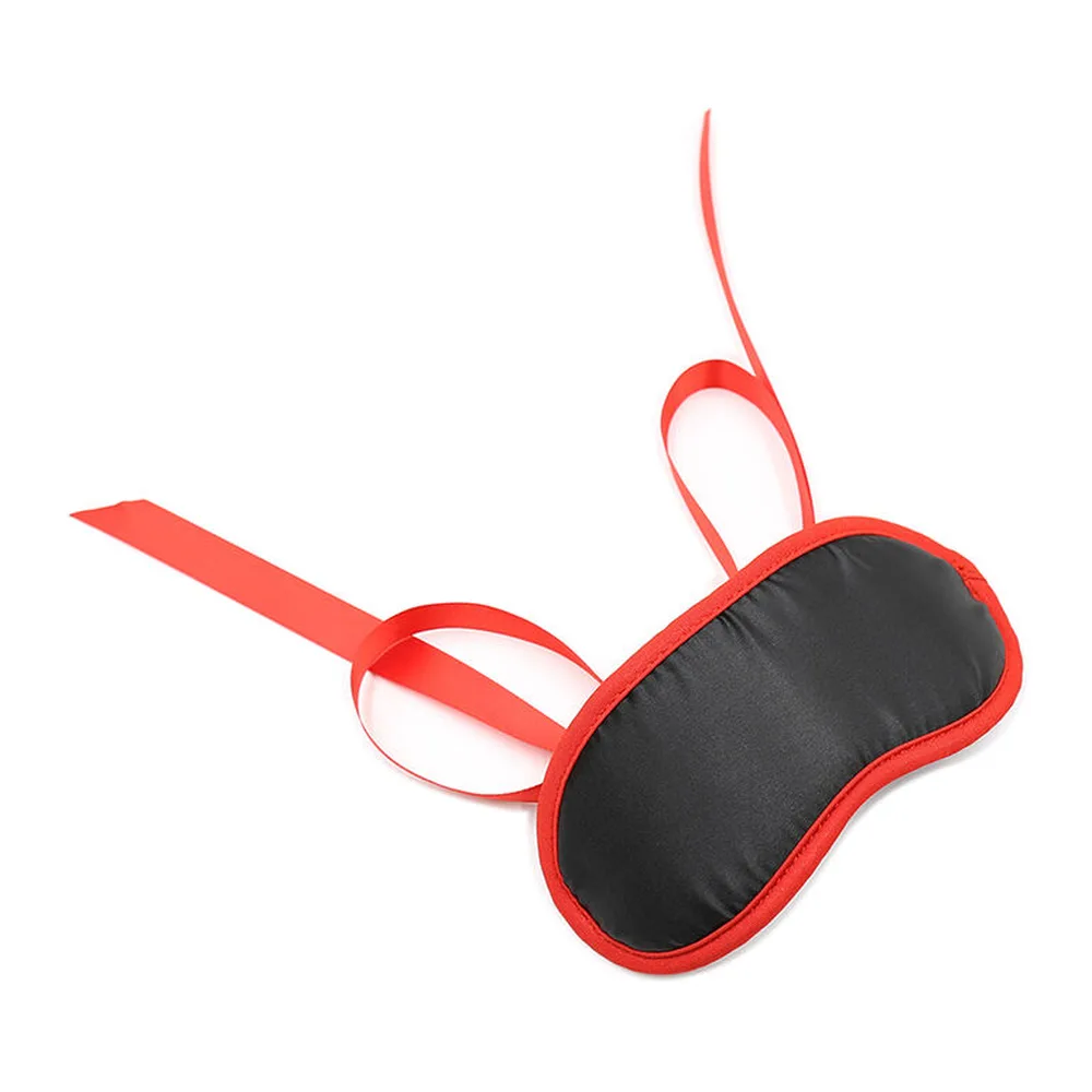 Masque de sommeil noir et rouge avec contour rouge vif et deux lanières nouables en satin rouge vif sur fond blanc