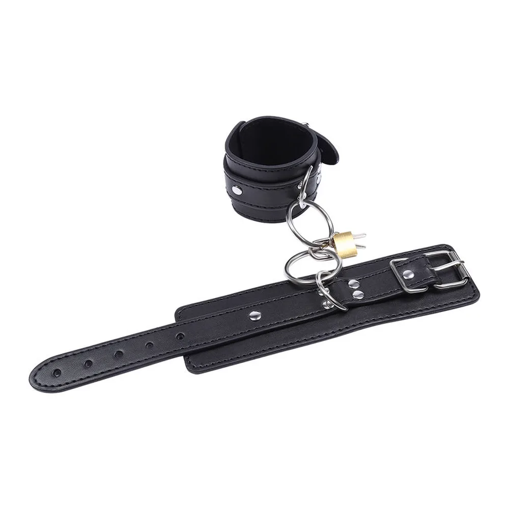 Paire de menottes en cuir noir avec anneaux métalliques, boucles et cadenas doré, sur fond blanc