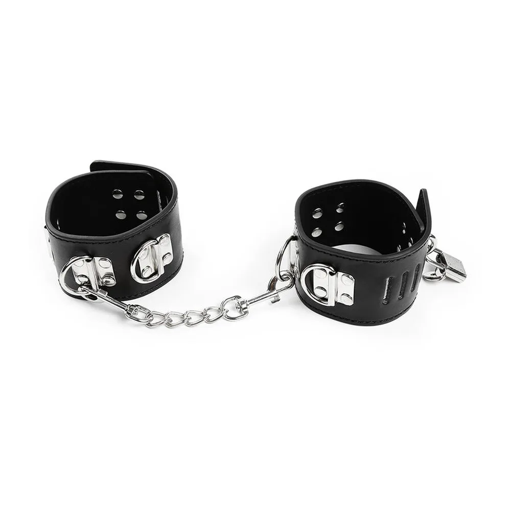 Paire de retenues chevilles en cuir noir avec fermoirs métalliques argentés, fentes de ventilation, anneaux de chaîne et cadenas, présentée avec chaîne de rallonge métallique