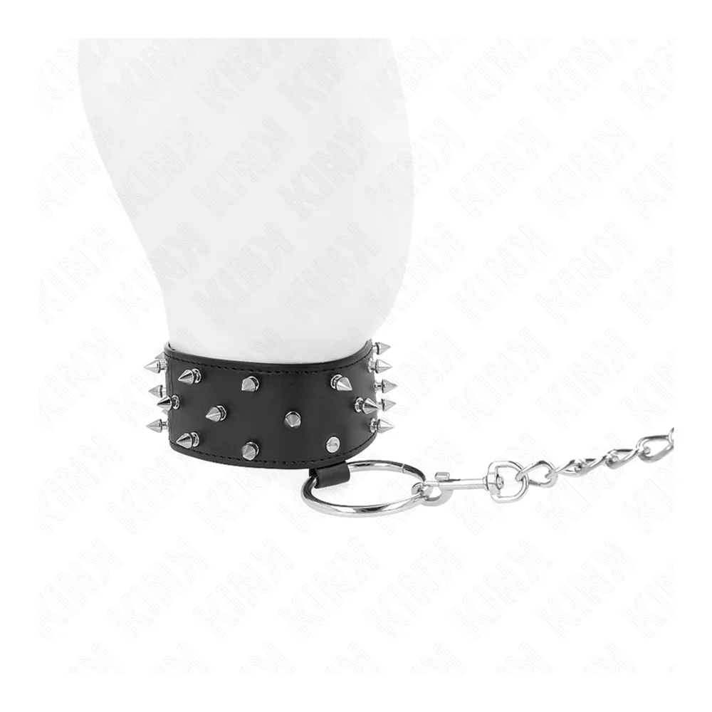 Collier de cuir noir orné de clous métalliques saillants, fermé par un anneau métallique, fond blanc