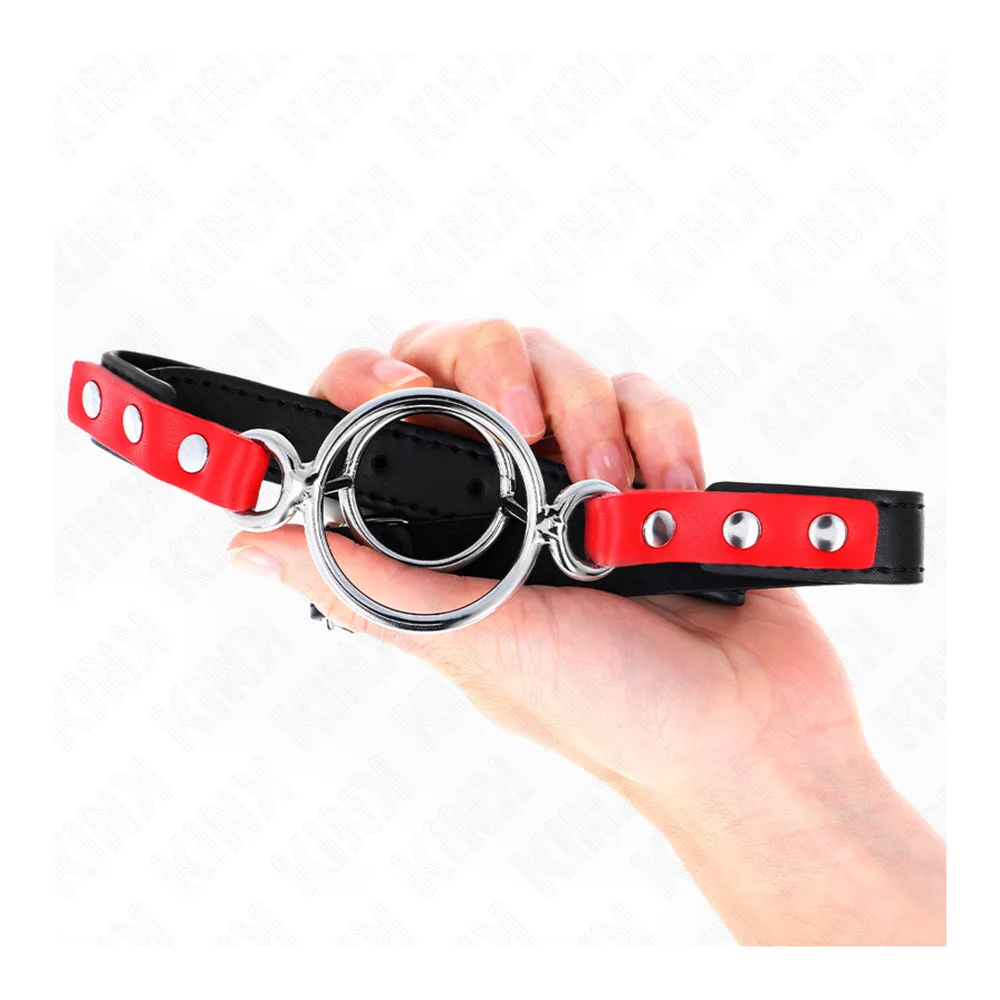 Bâillon à anneaux avec lanières rouge et noir ornées de rivets, anneau métallique central, fond blanc