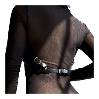 Harnais de gode-ceinture en tissu posé à plat sur un drap clair