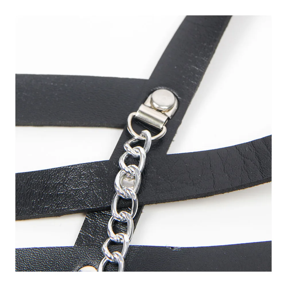 Harnais corset en cuir noir avec bretelles ajustables, ceinture à la taille et chaînes métalliques, porté sur un top transparent