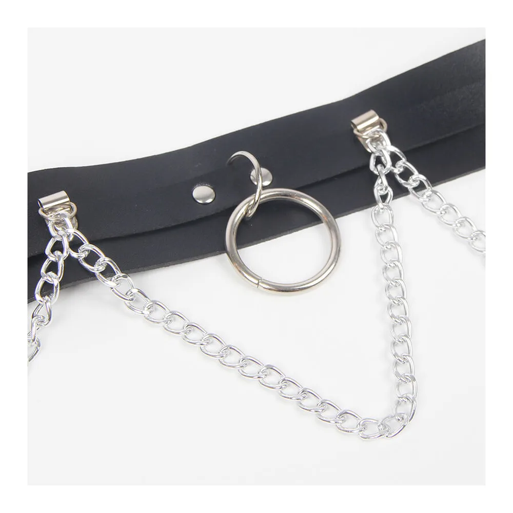 Harnais en cuir noir avec anneaux métalliques, sangles de cuisse et chaîne, fermoir à clip sur fond blanc