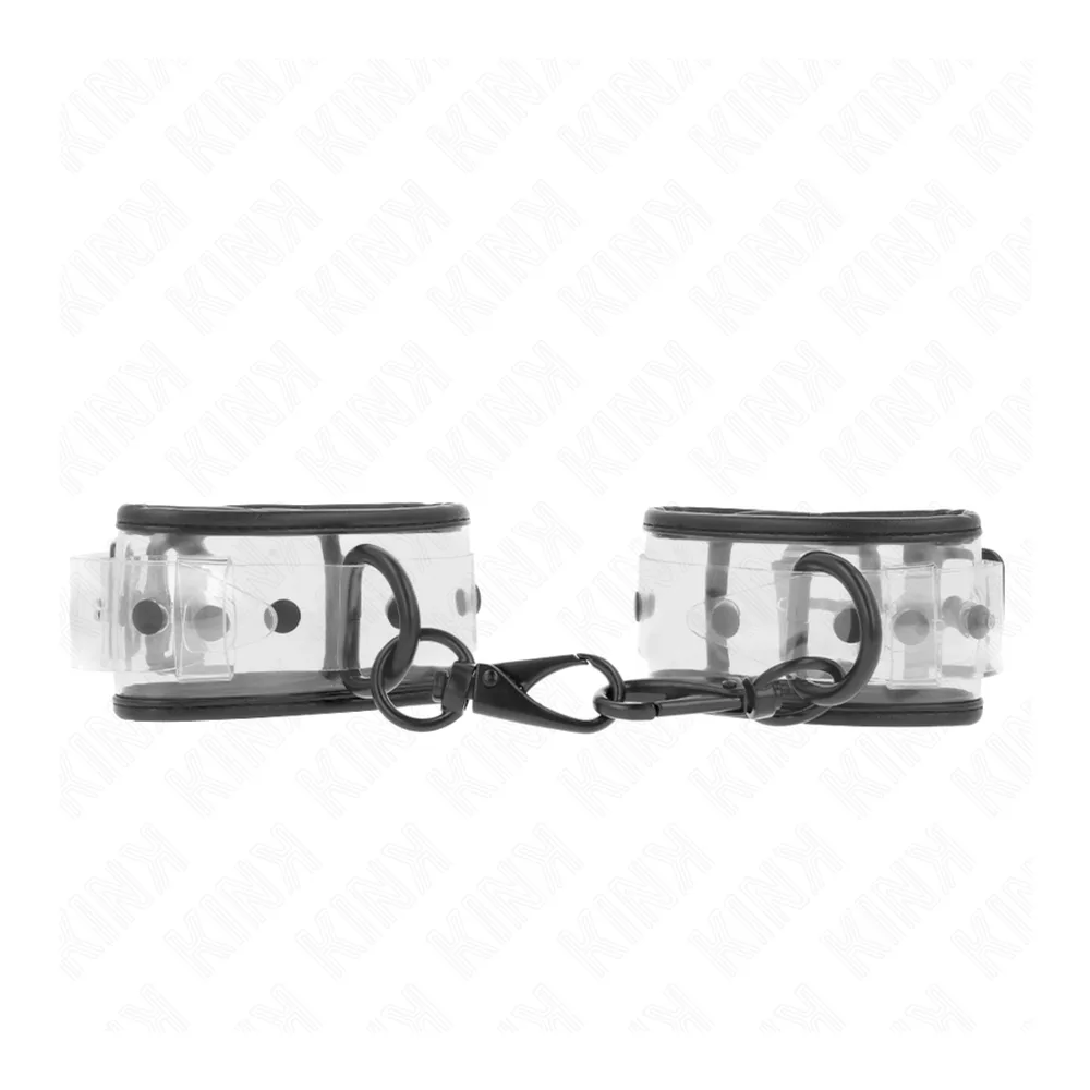 Paire de menottes transparentes avec bracelets en plastique clair et fermoirs noirs, reliées par une chaîne noire, vue de dessus sur fond blanc