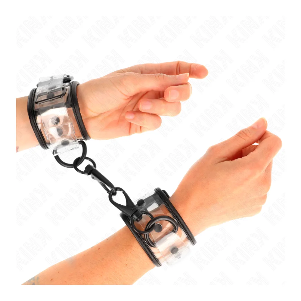 Paire de menottes transparentes avec bracelets en plastique clair et fermoirs noirs, reliées par une chaîne noire, vue de dessus sur fond blanc