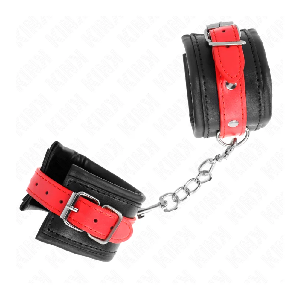 Paire de menottes en cuir noir et rouge avec bande contrastée rouge à clous argentés, reliées par une chaîne en acier inoxydable, sur fond blanc