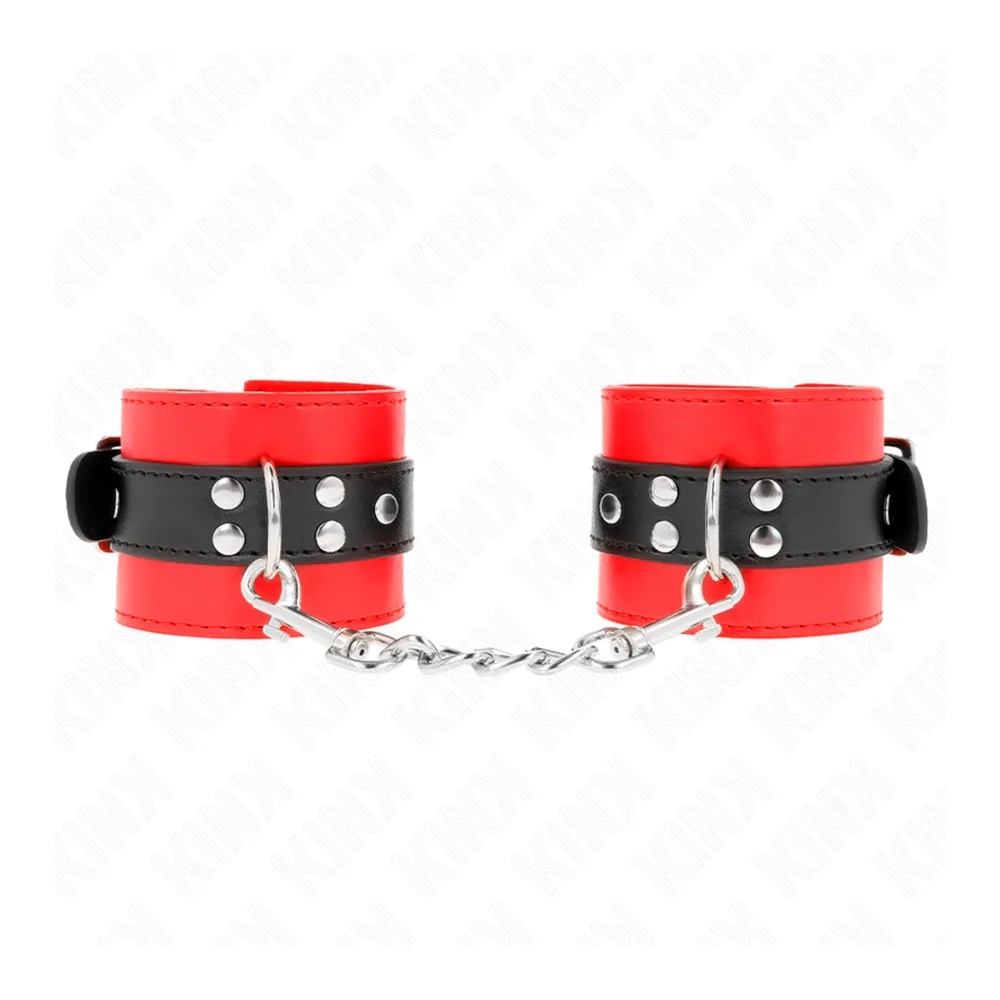 Paire de menottes aux poignets en cuir rouge et noir avec studs métalliques, reliées par une chaîne argentée, sur fond blanc