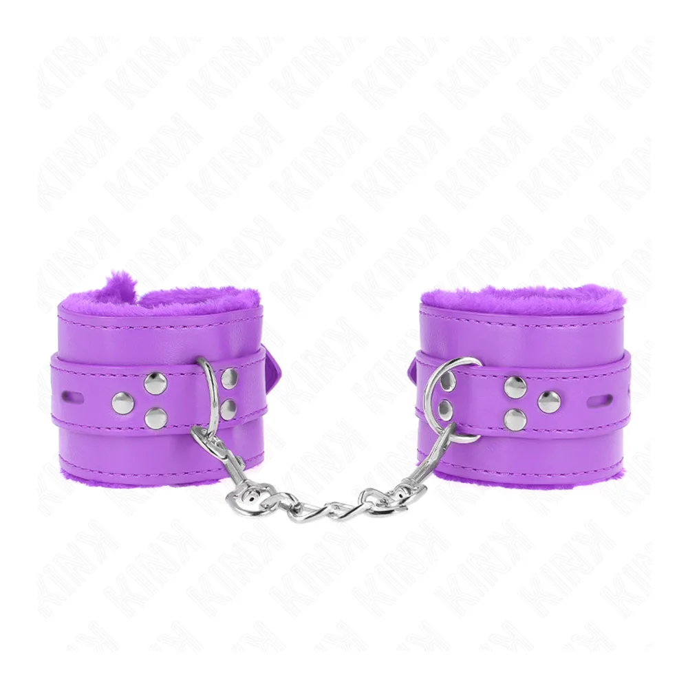 Paire de menottes en cuir synthétique violet avec doublure fourrure, larges bandes cloutées reliées par une chaîne métallique, surpiqûres visibles et anneau de fixation argenté