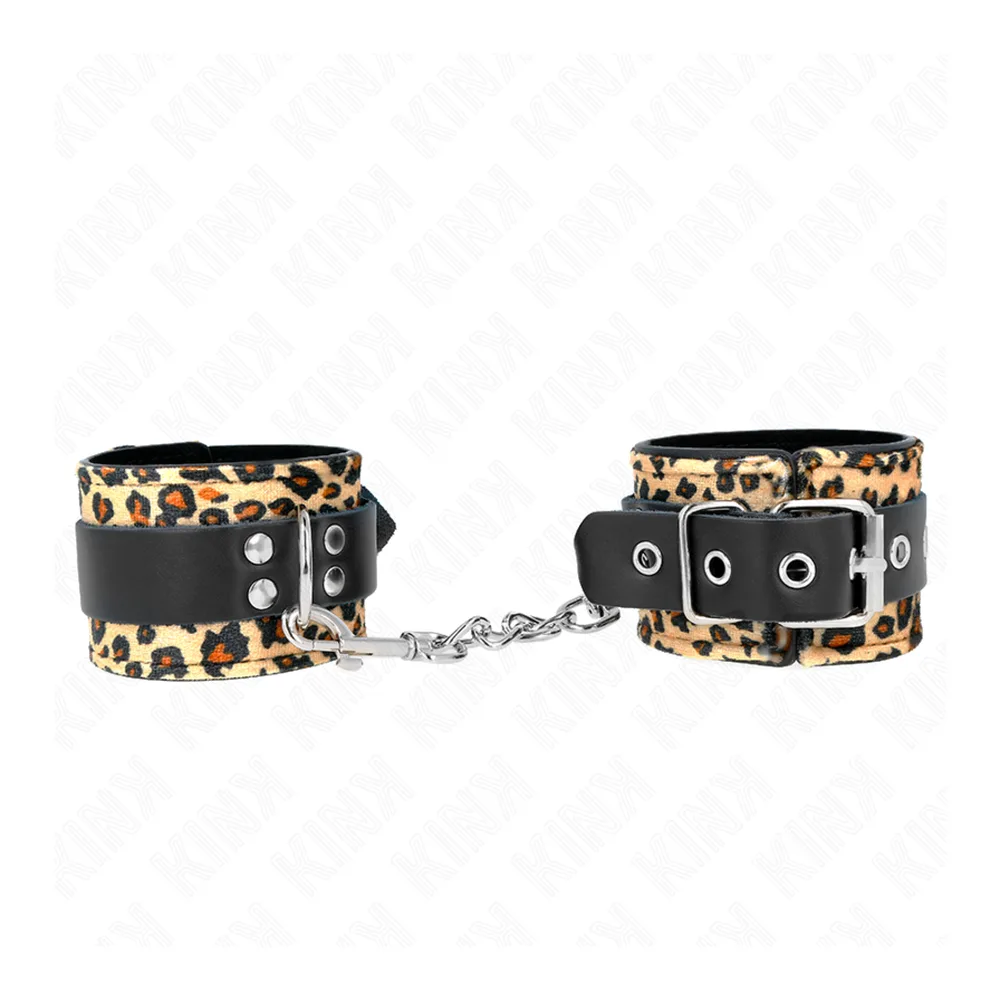 Menottes avec bracelet large en cuir motif léopard beige et noir, bande noire avec œillets métalliques, chaîne argentée de connexion