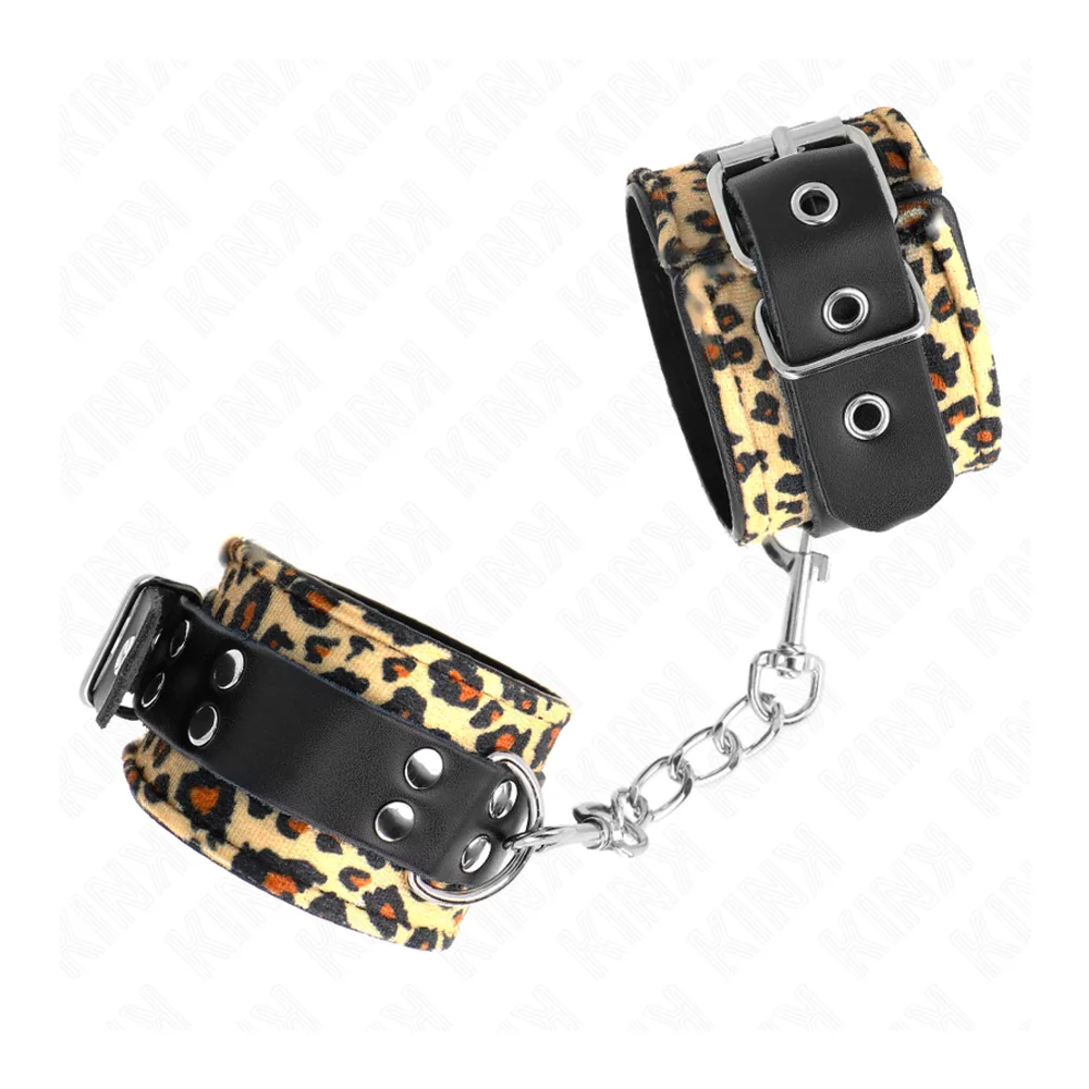 Menottes avec bracelet large en cuir motif léopard beige et noir, bande noire avec œillets métalliques, chaîne argentée de connexion