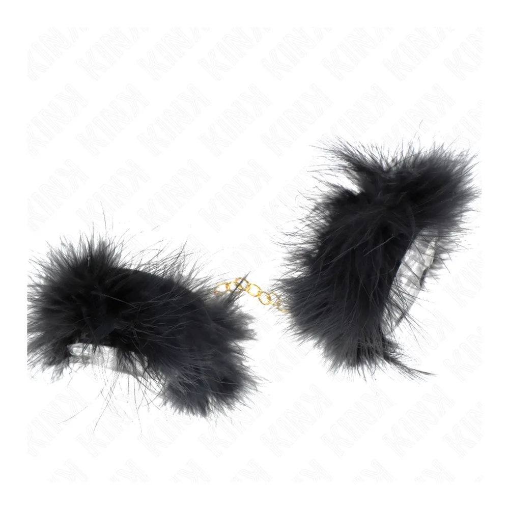Paire de manchettes en plumes noires fluffies reliées par une fine chaîne dorée, sur fond blanc