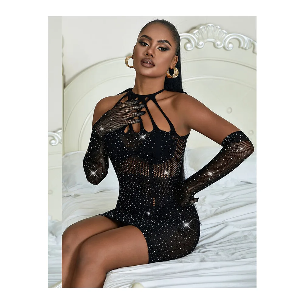 Robe courte noire en résille piquée de strass, encolure asymétrique avec découpes, manches longues ajourées, portée sur fond blanc