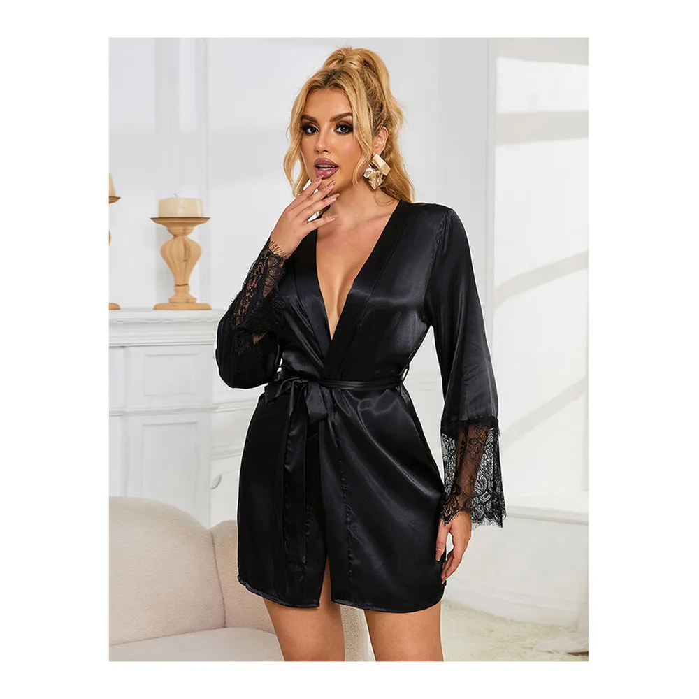 Nuisette courte en satin noir avec col en V profond, ceinture intégrée et manches longues finies de dentelle, dos ajouré en dentelle, portée sur fond blanc