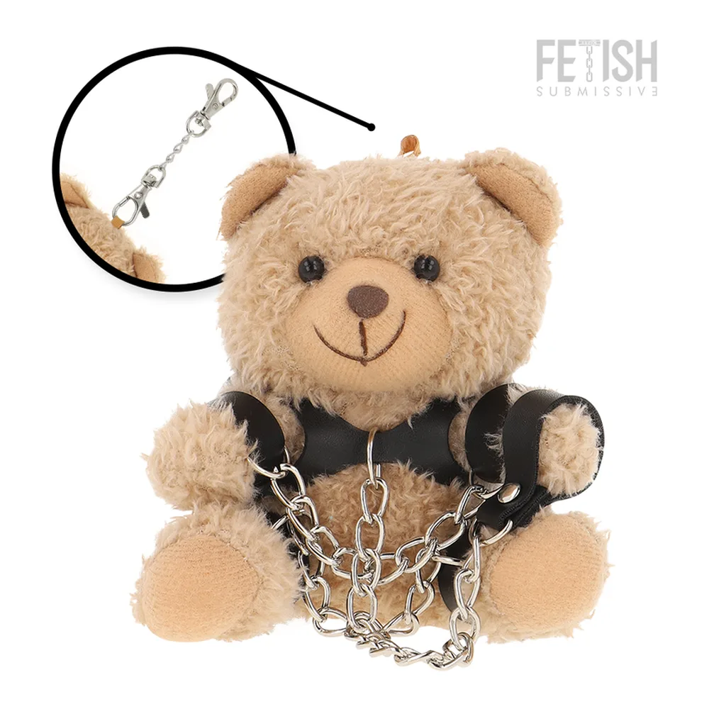 Peluche ours beige avec gilet noir en cuir, menottes à chaîne métallique, schéma de dimensions indiquant 151 mm de hauteur et 107 mm de largeur