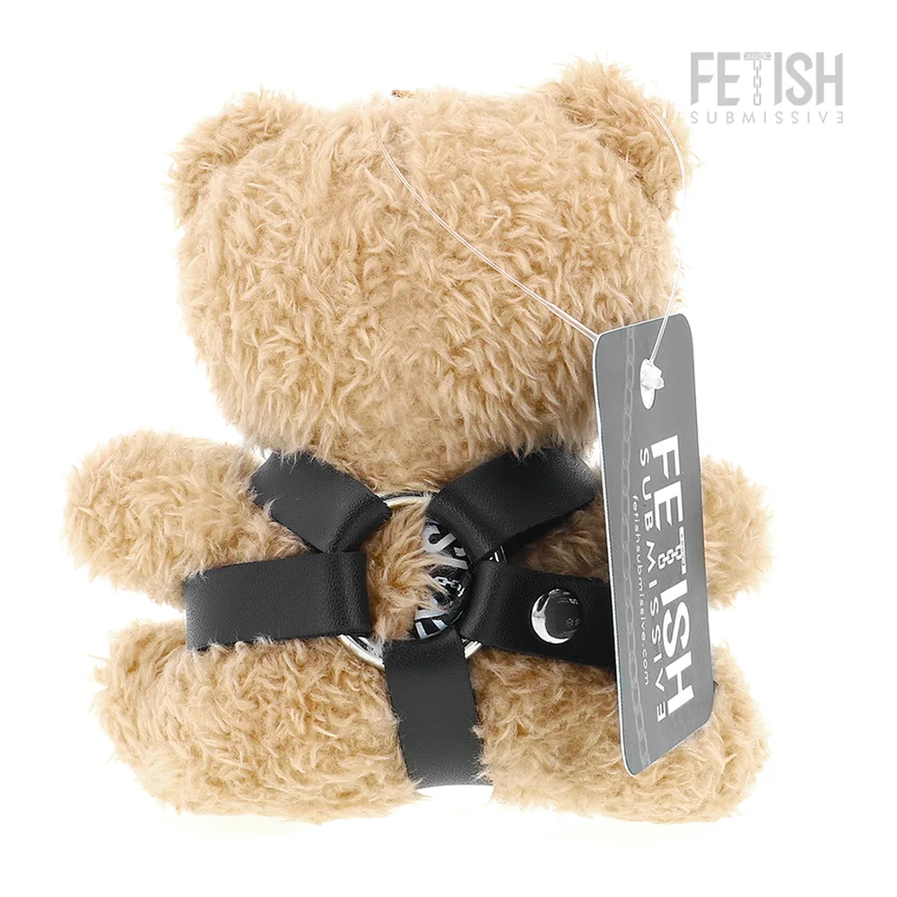 Ours en peluche beige avec harnais noir à studs argentés et laisse noire avec mousquetons, sourire brodé, infobulle montrant le détail de la chaîne de connexion