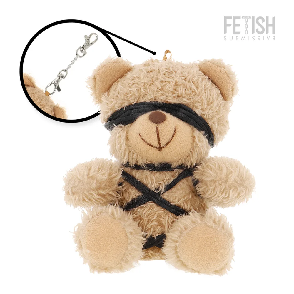 Peluche ours beige en velours avec bandeau noir, harnais en cordages noirs, et lanière d'attache avec mousquetons métalliques