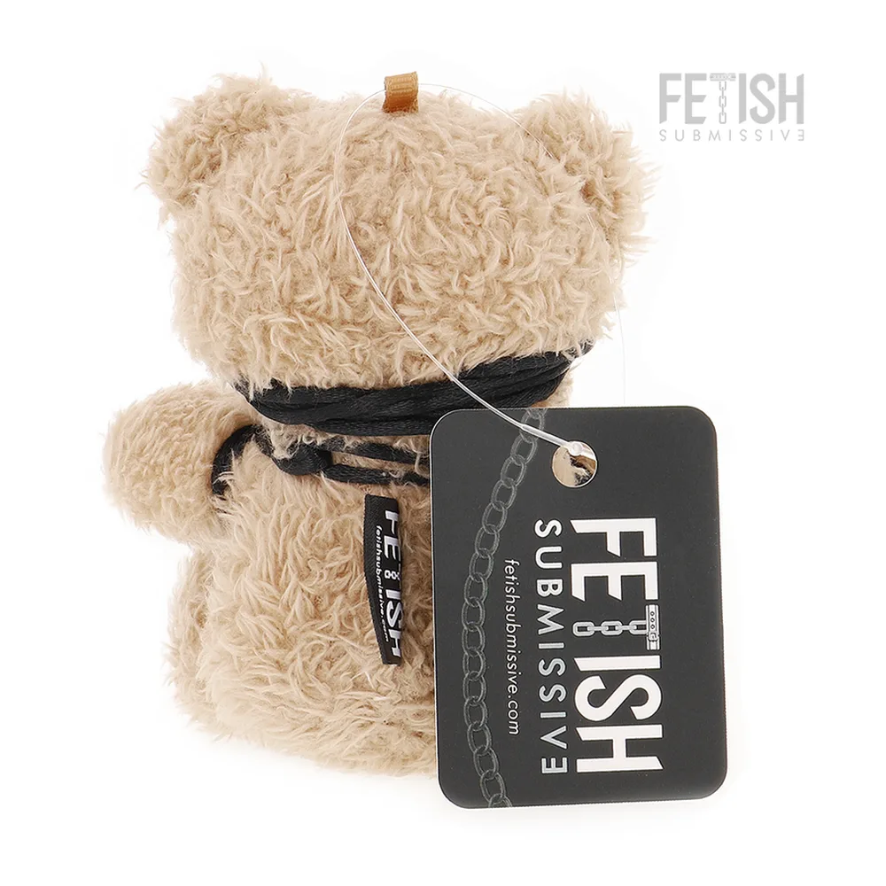 Peluche ours beige en velours avec bandeau noir, harnais en cordages noirs, et lanière d'attache avec mousquetons métalliques