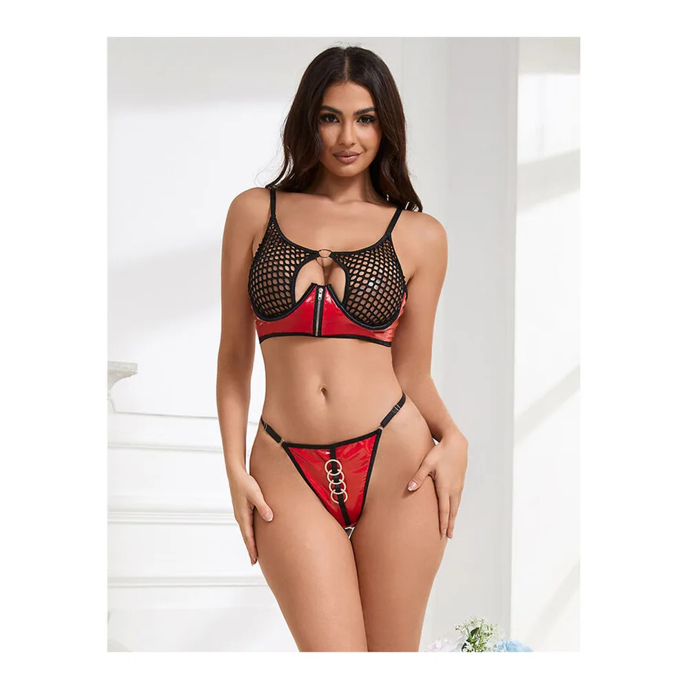 Détail de soutien-gorge noir en similicuir ajouré avec motifs géométriques blancs et anneau métal argenté, fermeture éclair visible