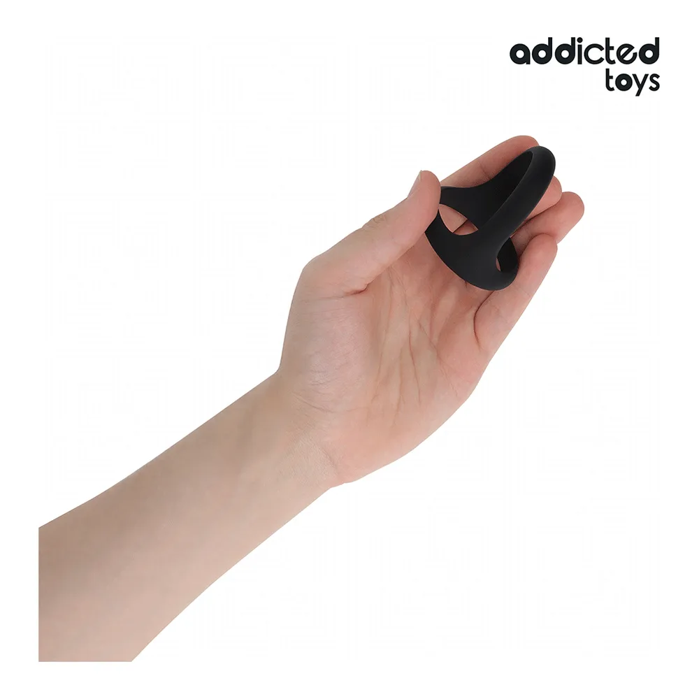 Cockring noir en silicone épais avec trois boucles, présenté dans son emballage blanc et noir de la marque Addicted Toys