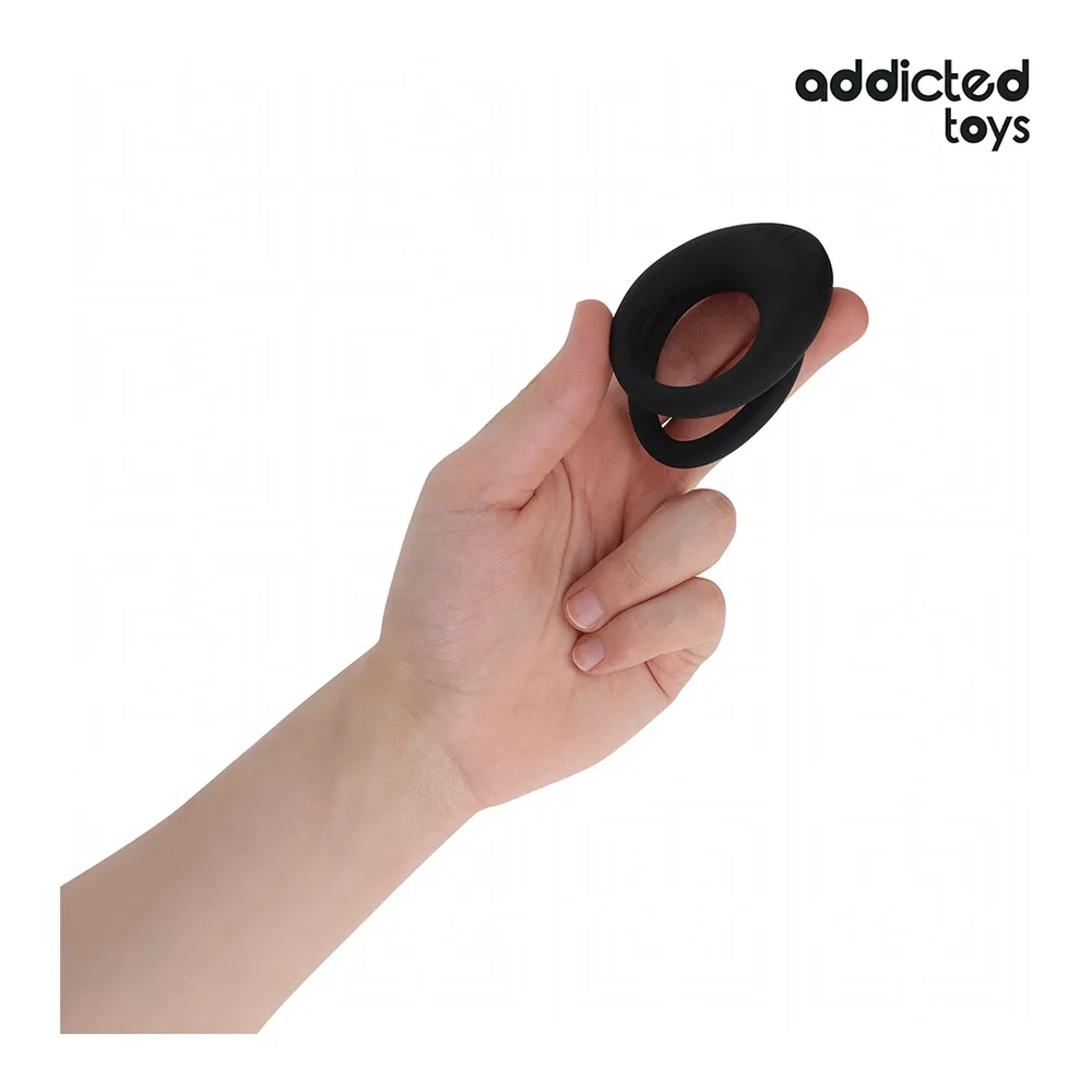 Anneau en silicone noir avec double structure, texturé sur la partie supérieure, conçu pour enserrer le pénis et les testicules