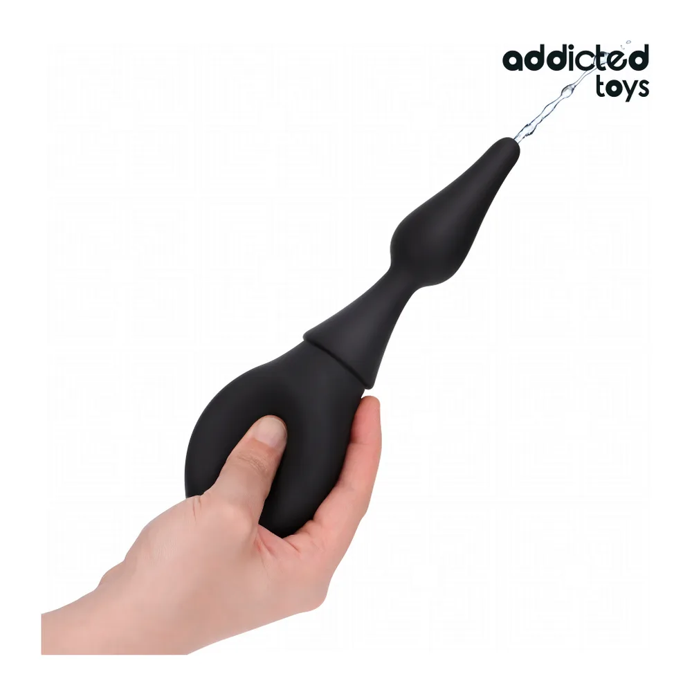 Poire de nettoyage noire avec embout épais, tenue en main, connectée à un tube transparent, sur fond blanc