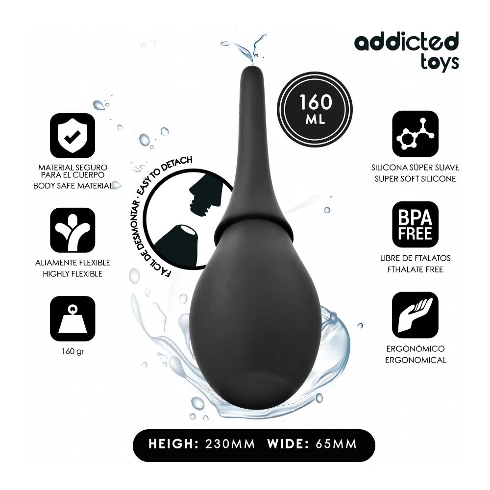Nettoyeur de voyage noir avec poire en silicone et embout fin détachable, tenu à la main sur fond blanc