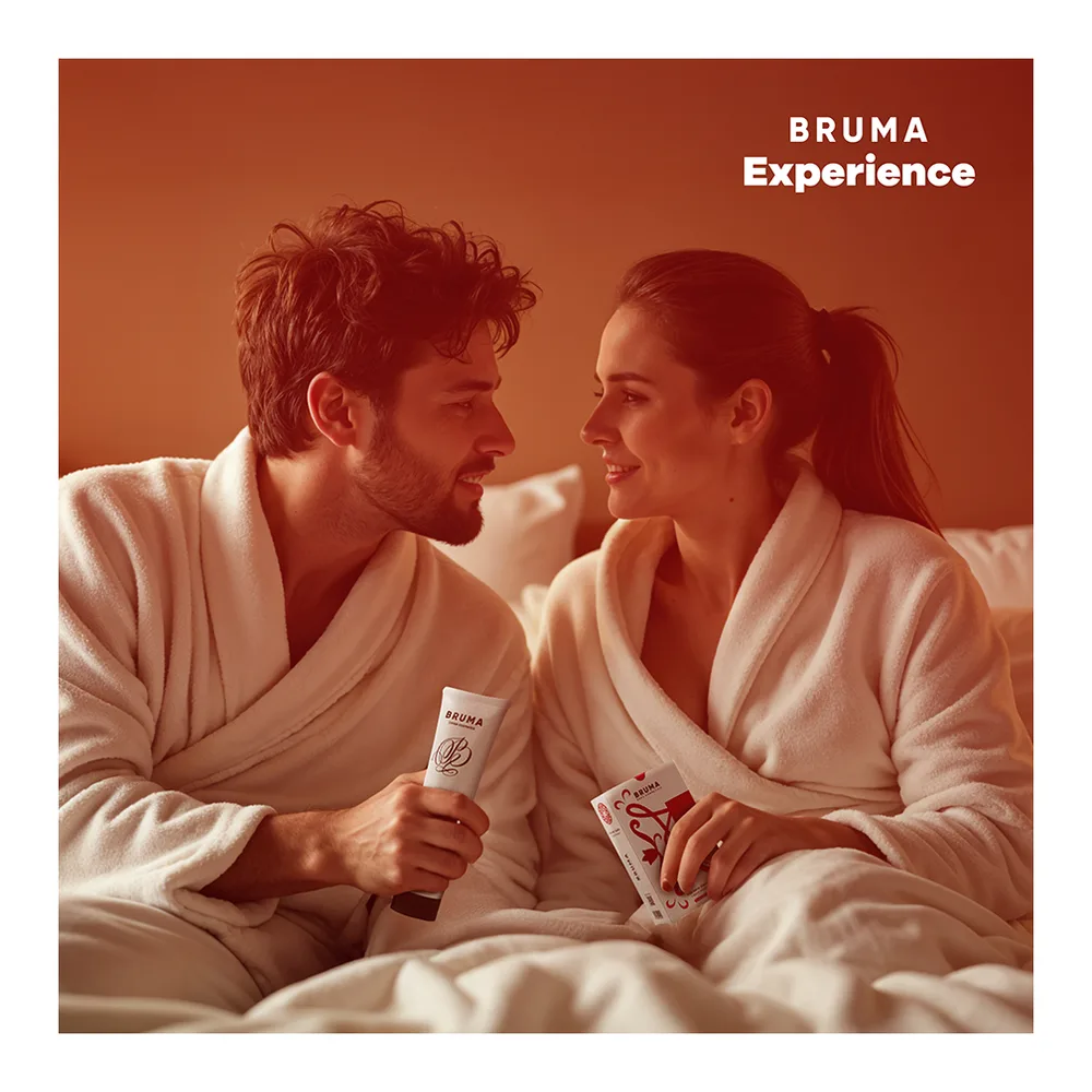 Coffret BRUMA Experience avec emballage blanc présentant un schéma des composants : lubrifiant aromatisé, huile de massage 3 en 1, bandeau satin et plumes à chatouillement