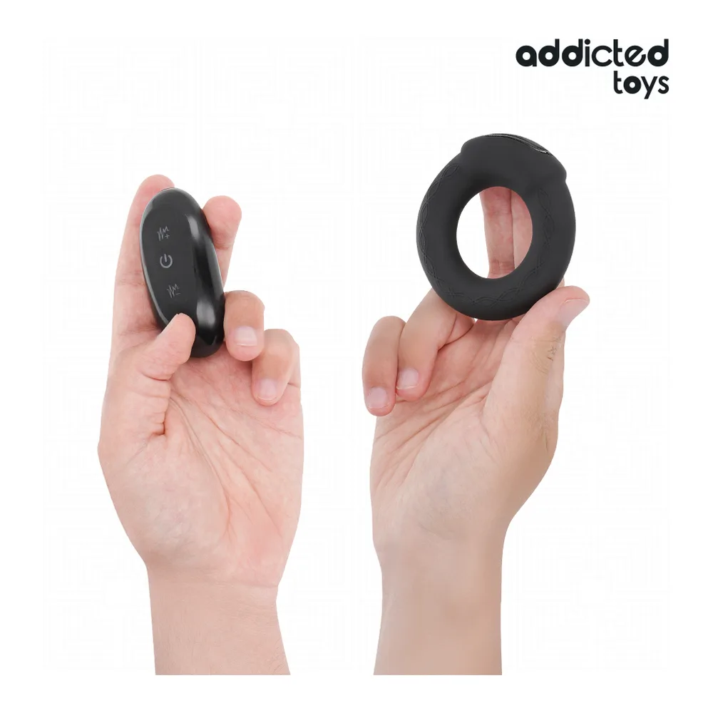 Cockring anneau noir en silicone avec textures, emballage blanc Addicted Toys ouvert montrant le produit et sa télécommande grise, vue d'ensemble du kit complet