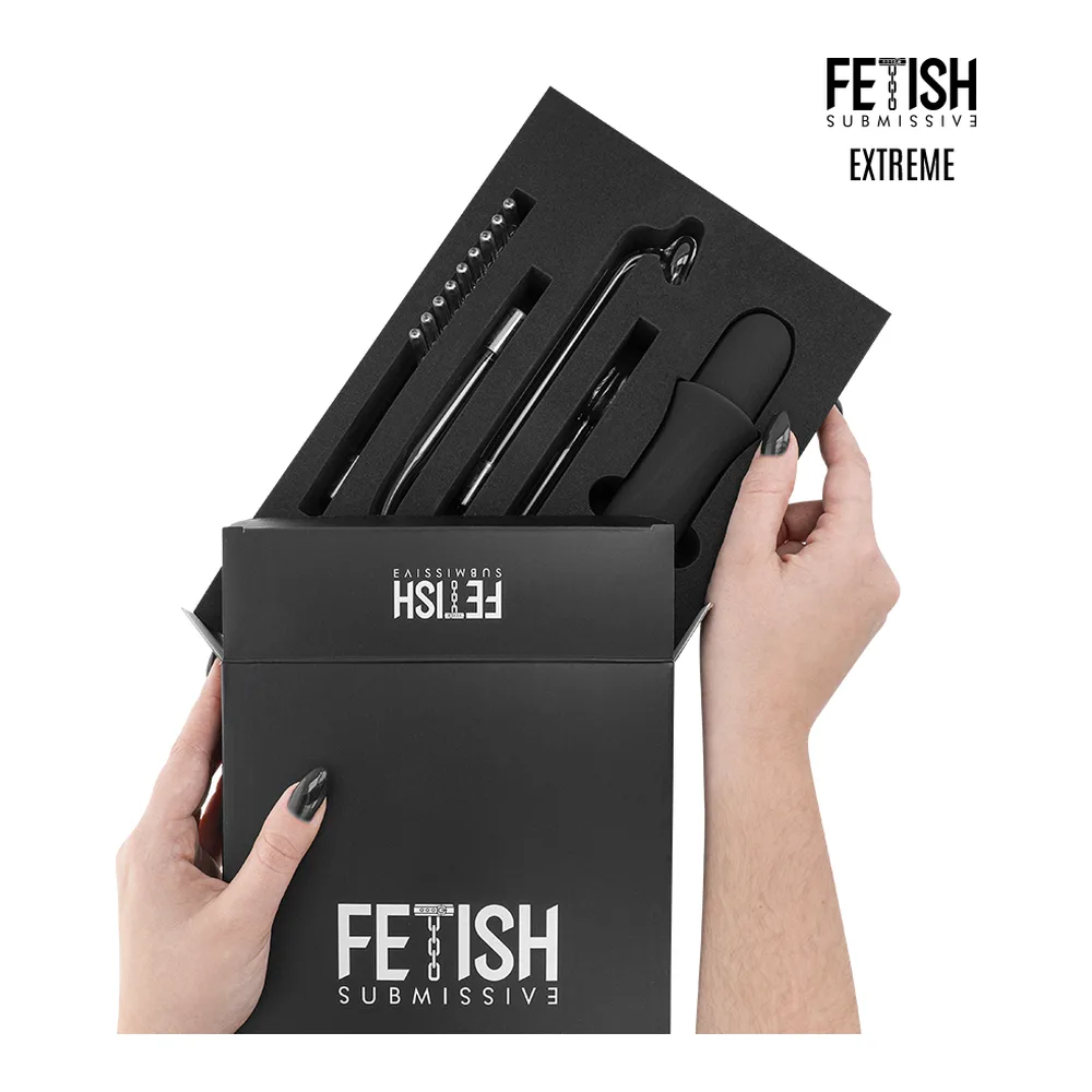 Coffret noir ouvert contenant un wand d'électrostimulation rechargeable noir brillant avec quatre têtes interchangeables incluant des embouts en verre, tenu par deux mains manucurées sur fond blanc