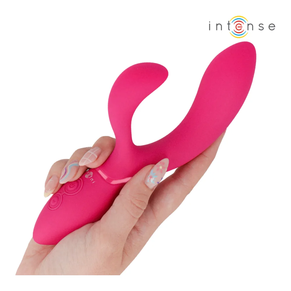 Stimulateur en silicone rose fuchsia tenu en main, avec un bras clitoridien et une tige articulée, présents les reliefs texturés de commandes tactiles