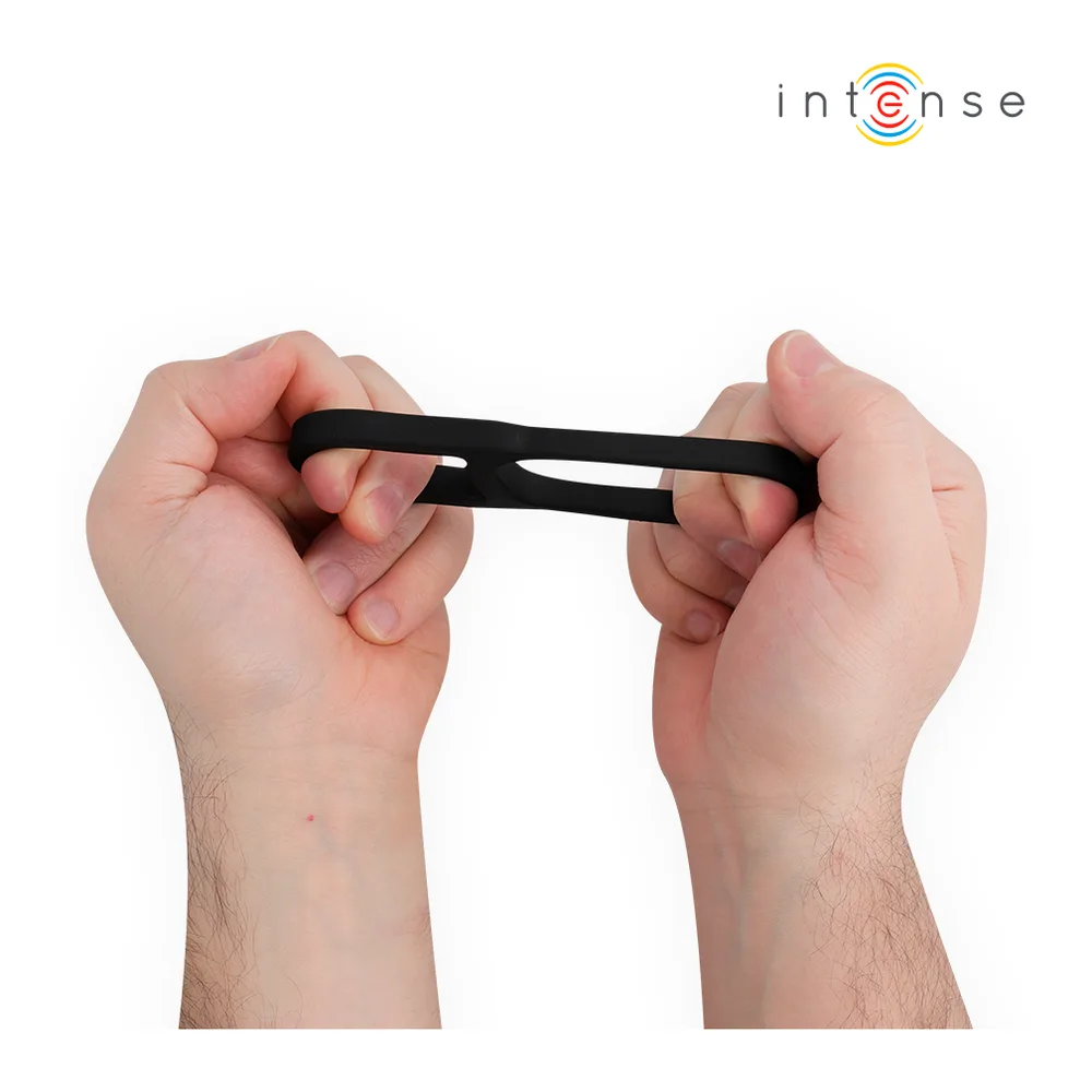 Deux mains tenant un fin anneau pénis noir extensible, montrant sa flexibilité et sa structure double