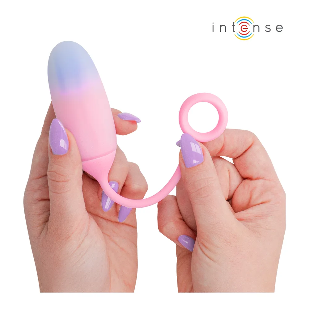 Vibromasseur rose dégradé bleu-mauve tenu en main, avec anneau rose à la base pour le doigt et tête arrondie incurvée, sur fond blanc