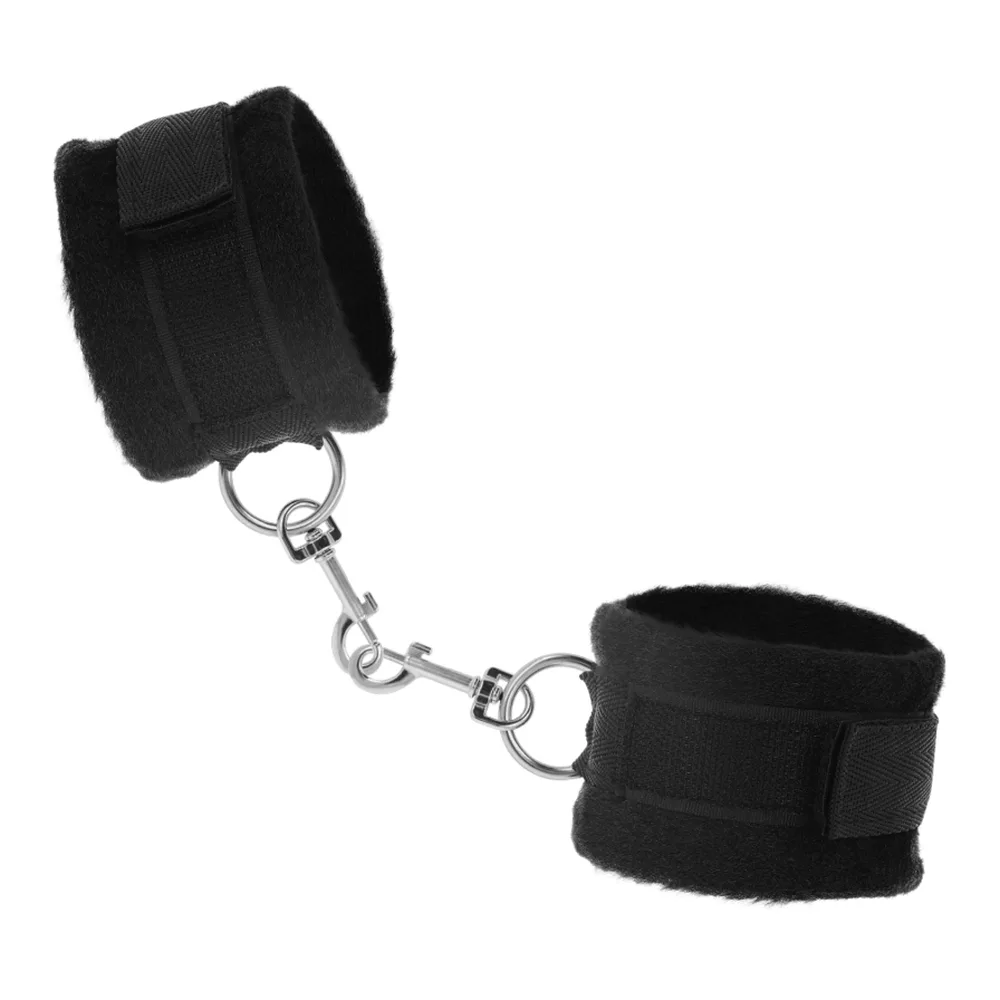 Paire de menottes noires en fourrure synthétique avec chaîne métallique et anneaux, fermoirs velcro, sur fond blanc