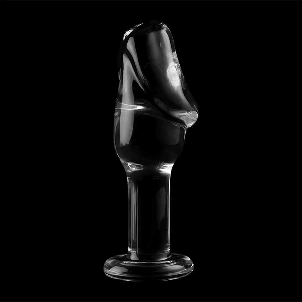 Plug anal en verre transparent avec tête bombée sculptée en biseau, col étroit et base évasée circulaire, sur fond blanc